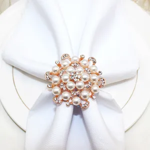 Detailed close-up of a rose gold floral napkin ring adorned with pearls and sparkling rhinestones.