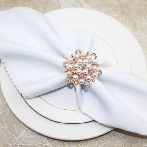 Detail shot of exquisite rose gold pearl rhinestone flower napkin ring for elegant table setting decor.