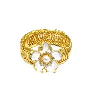 Goldene Feder Vorhangklammer Detail mit weisser Emaille Blume Perle und Strasssteinen.