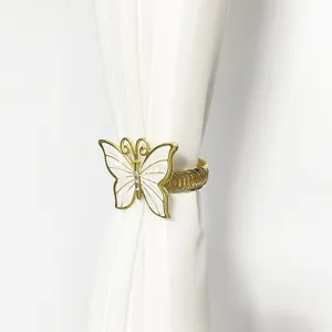 Dettaglio dell'abbraccia tenda a farfalla dorata con strass e molla elastica regolabile.