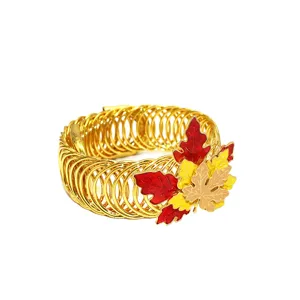 Gold metal spring curtain tieback detail, elegant tricolor enamel maple leaf design for decor.