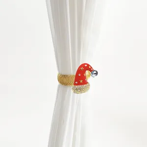Gold metal spring curtain tieback featuring a festive red rhinestone Santa hat design.