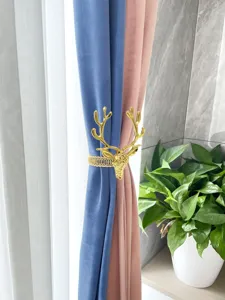 Vista dettagliata del fermatenda in metallo dorato testa di cervo, accessorio decorativo.