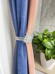 Close up of a sparkling crystal flower curtain tieback with flexible spring band holding stylish drapes.