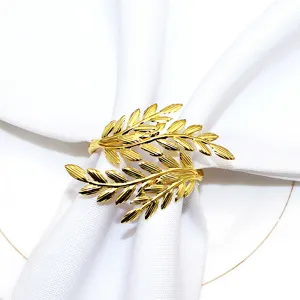 Detailed shot of a gold leaf napkin ring holding a white napkin on a plate, close up.