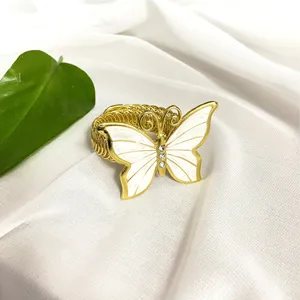 Fermatenda a farfalla dorato, elegante fibbia per tendaggi in metallo con smalto bianco.