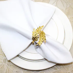 Detail shot of gold leaf metal napkin ring showcasing exquisite texture on white table napkin.