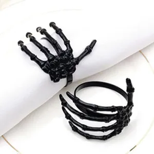 Black skeleton hand napkin rings for Halloween table decor, gothic dinner party accents.