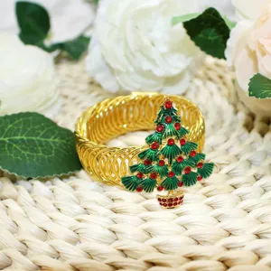 Gold metal spring curtain tieback featuring green enamel Christmas tree with red rhinestones.