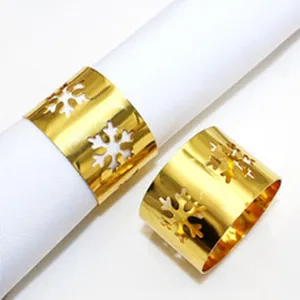 Gold metal napkin rings with hollow snowflake design for hotel and table decoration.