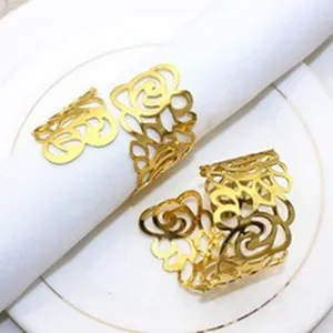 Close-up detail of gold metal hollow floral napkin rings, elegant table decor accessory.