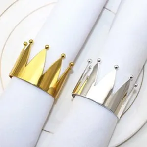 Metal crown napkin ring detail shot, elegant gold and silver table decor for hotel dining.