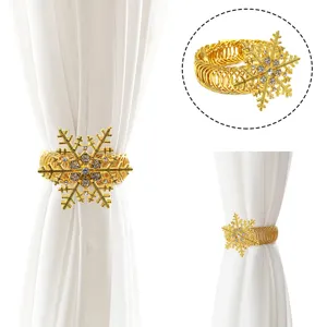 Dettaglio fermatenda fiocco di neve dorato, elegante legatenda a molla con strass brillanti.