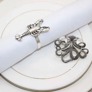 Detailed close-up view of vintage silver marine life napkin rings featuring lobster and octopus designs.