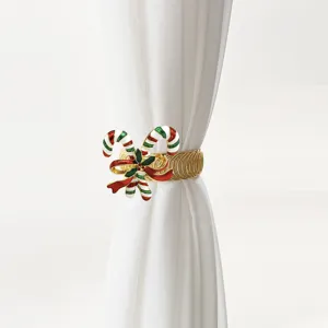 Christmas candy cane curtain tieback detail view, golden metal spring clip holiday decoration.