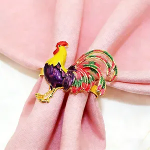 Close-up detail of the colorful enamel rooster metal napkin ring, perfect for party table decor.