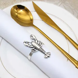Detailed close-up of a vintage silver lobster napkin ring holding a clean white napkin.