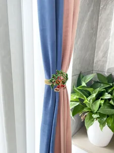 Metal spring curtain tieback featuring a Christmas bell and holly wreath design, detail view.