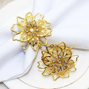 Gold metal flower napkin ring closeup with sparkling rhinestones, elegant table decor detail shot.