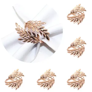 Metal leaf napkin rings in rose gold, elegant table decor for weddings and restaurants detail.