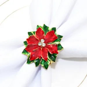 Close-up detail of a Christmas poinsettia flower napkin ring with red enamel and rhinestones.
