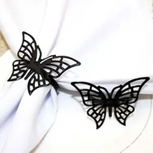 Detailed view of elegant black hollow butterfly napkin rings, perfect for dining table decor.