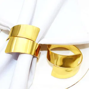 Detailed view of elegant gold metal napkin rings, perfect for hotel table decor and weddings.