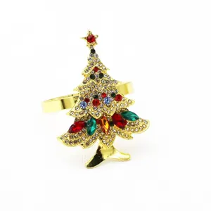 Rond de serviette sapin de noel strass, metal dore, detail de deco de table festive.