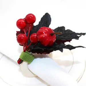 Halloween napkin ring detail view showing red berries, black leaves, and pumpkin decor.
