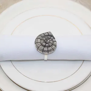 Detailed close-up of the vintage spiral seashell napkin ring with exquisite metallic texture.