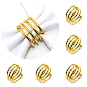 Gold metal spring napkin rings set for hotel table decor and table setting details.