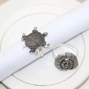 Metal napkin rings set featuring vintage marine life turtle and shell designs for table decor.