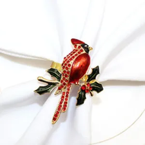 Close-up detail of a sparkling red cardinal bird napkin ring with holiday holly leaves design.