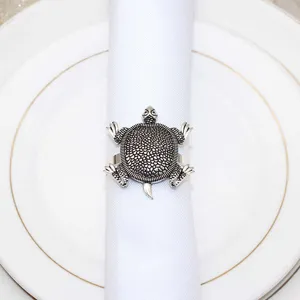 Detail view of a vintage silver metal turtle napkin ring showcasing intricate shell carving.