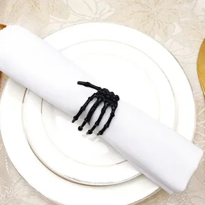 Black skeleton hand napkin ring detail view on white dinner plate for Halloween dining decor