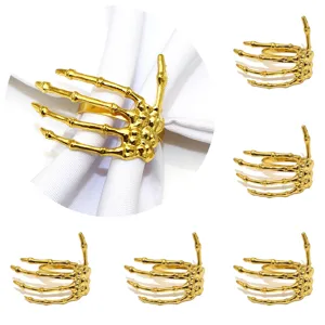 Gold skeleton hand napkin ring detail view showing elegant Halloween table decor and metallic shine.
