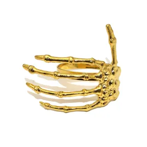 Close up view of gold skeleton hand napkin ring, ideal for Halloween party table decor.