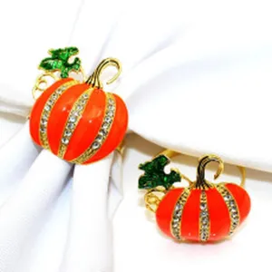 Enamel pumpkin napkin ring with rhinestones and green leaves detail close-up view.