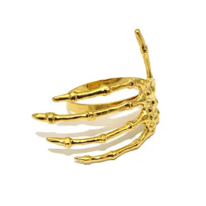 Gold skeleton hand napkin ring detail shot, unique Halloween table decor table setting accessory.