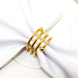 Gold metal napkin ring with spring design and double beads, perfect for table decor detail.