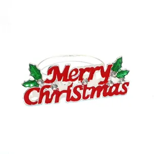Detail shot of silver metal Christmas napkin ring with red letters and sparkling rhinestones.