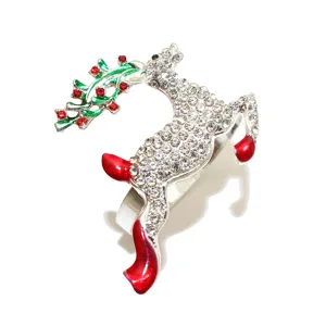 Close-up of a sparkling rhinestone reindeer napkin ring with red enamel details for Christmas.