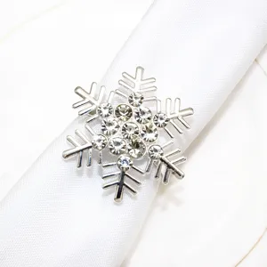 Detailed close-up of a sparkling rhinestone snowflake napkin ring on white fabric.
