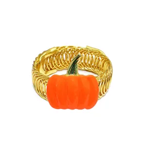 Detailed view of gold metal spring curtain tieback with vibrant orange enamel pumpkin decor.