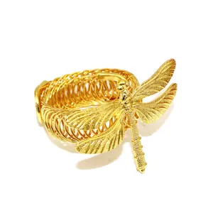 Nahaufnahme der goldenen Libellen-Vorhangklammer mit flexiblem Metallfederband.