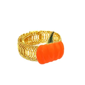 Gold metal spring curtain tieback with orange pumpkin detail, closeup view for home decor.