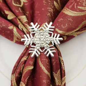 Close-up of a sparkling crystal snowflake napkin ring with red gold fabric napkin for holiday decor.