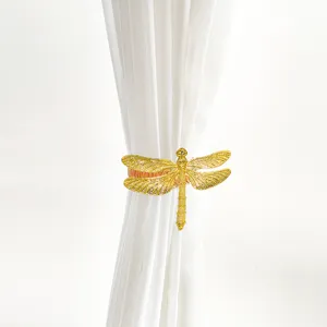 Goldene Libelle Vorhangschnalle Detail, Metallfeder Raffhalter, elegante Fenster Dekoration.