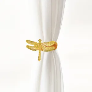 Goldene Libelle Vorhanghalter Detailaufnahme, eleganter Metallfederclip für Heimtextilien und Fenster.