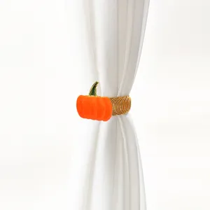 Pumpkin curtain tieback detail, gold metal spring clip for home drapery decoration.